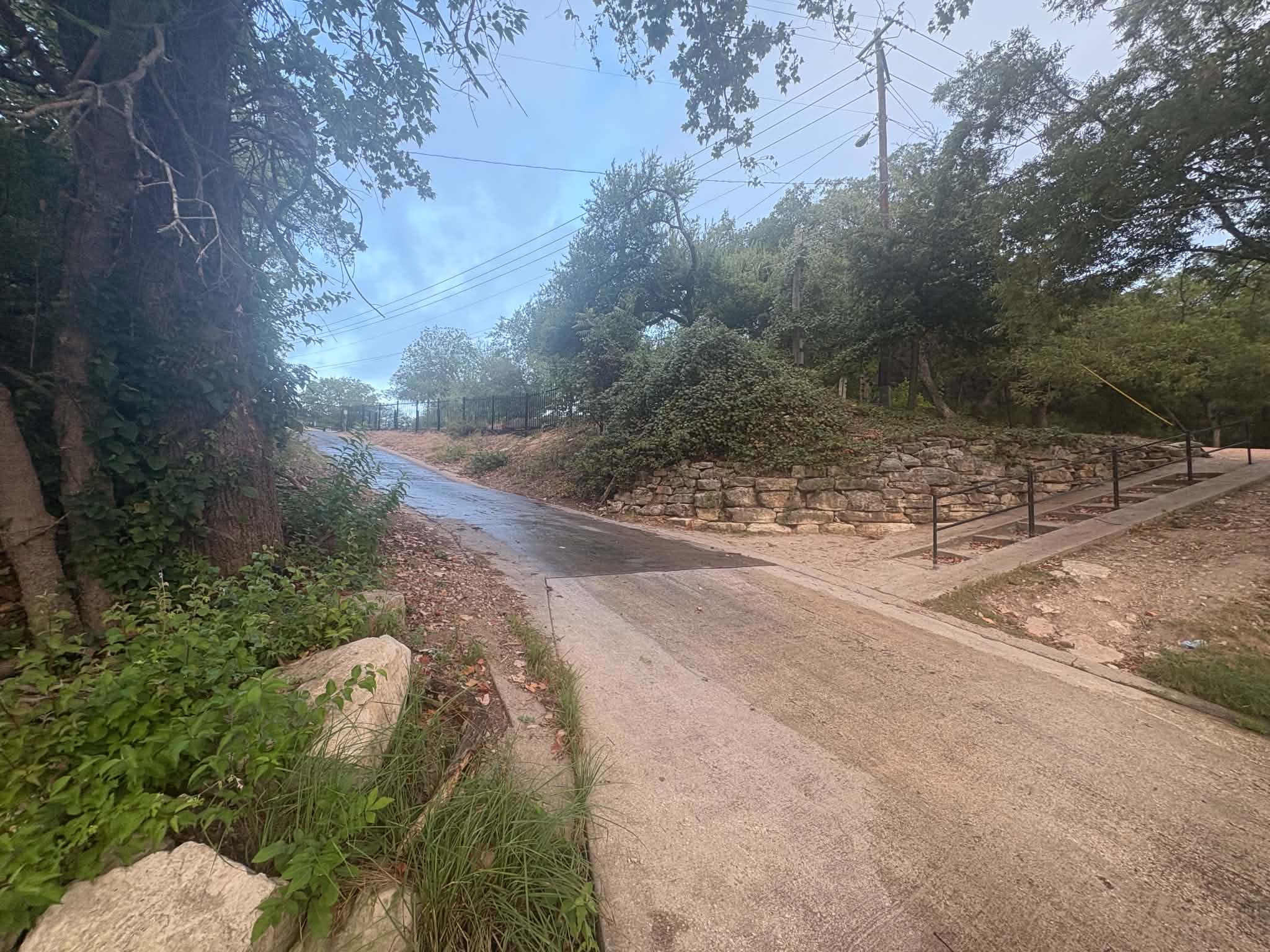 View from the Apache Shores boat ramp looking toward Lake Austin on a misty early morning, as if a boat were being pulled out of the water, with calm water and the shoreline fading into the fog.