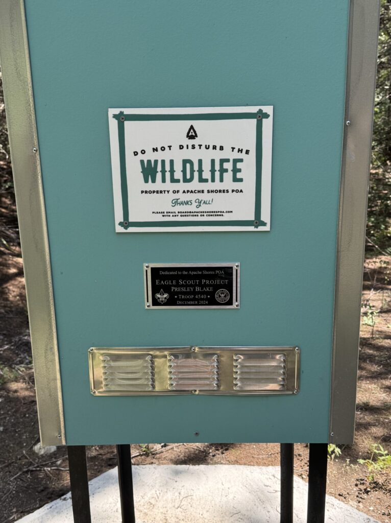 Close-up of the Apache Shores Chimney Swift Tower showing the wildlife protection sign, Eagle Scout project plaque, and ventilation opening.